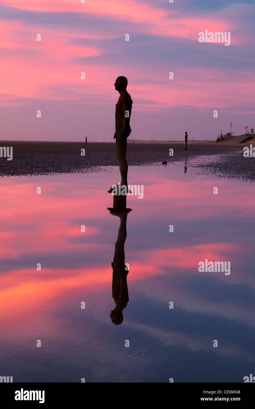 Antony Gormley Statue silhouettiert, Twilight, ein weiterer Ort Crosby. Stockfoto