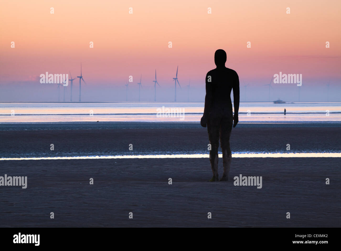 Antony Gormley Statue silhouettiert, Twilight, ein weiterer Ort Crosby. Stockfoto