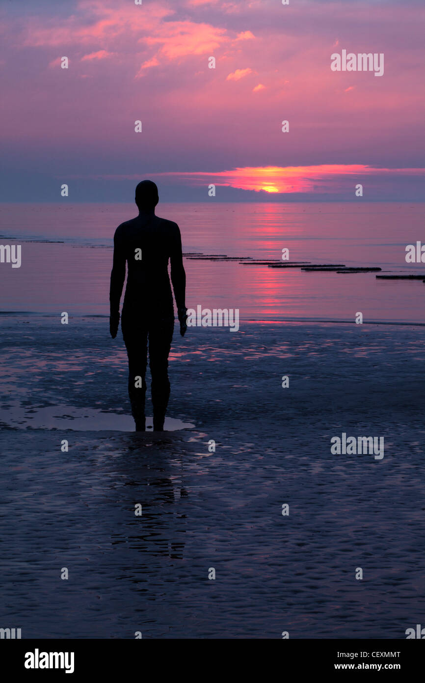 Antony Gormley Statue der Silhouette.  Sonnenuntergang, ein weiterer Ort Crosby. Stockfoto