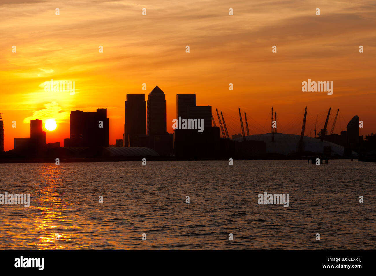 Ein Blick auf th Fluss Themse gegenüber der City of London und die O2 Arena und Canary Wharf bei Sonnenuntergang Stockfoto