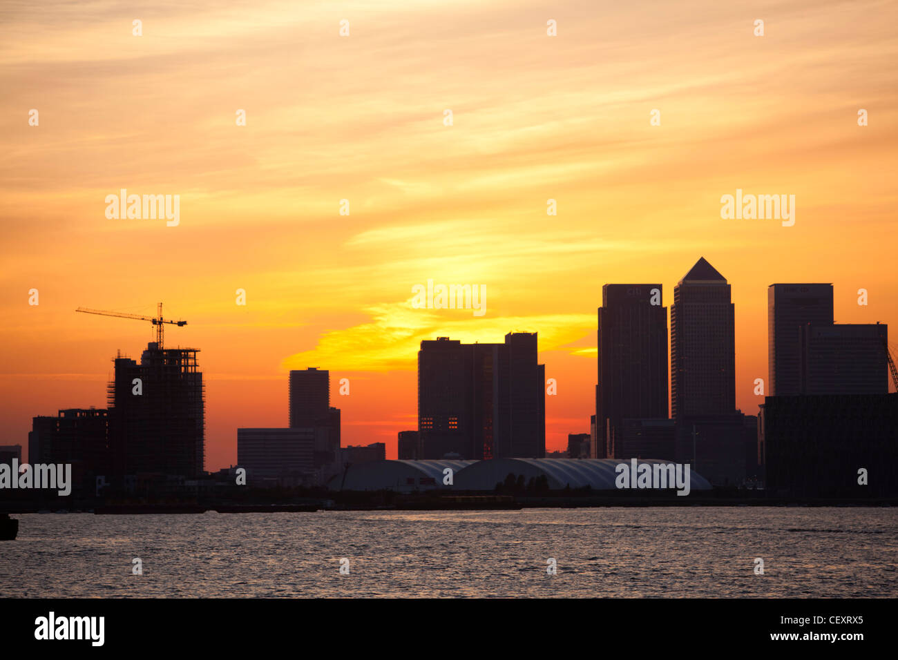 Ein Blick auf th Fluss Themse gegenüber der City of London und die O2 Arena und Canary Wharf bei Sonnenuntergang Stockfoto