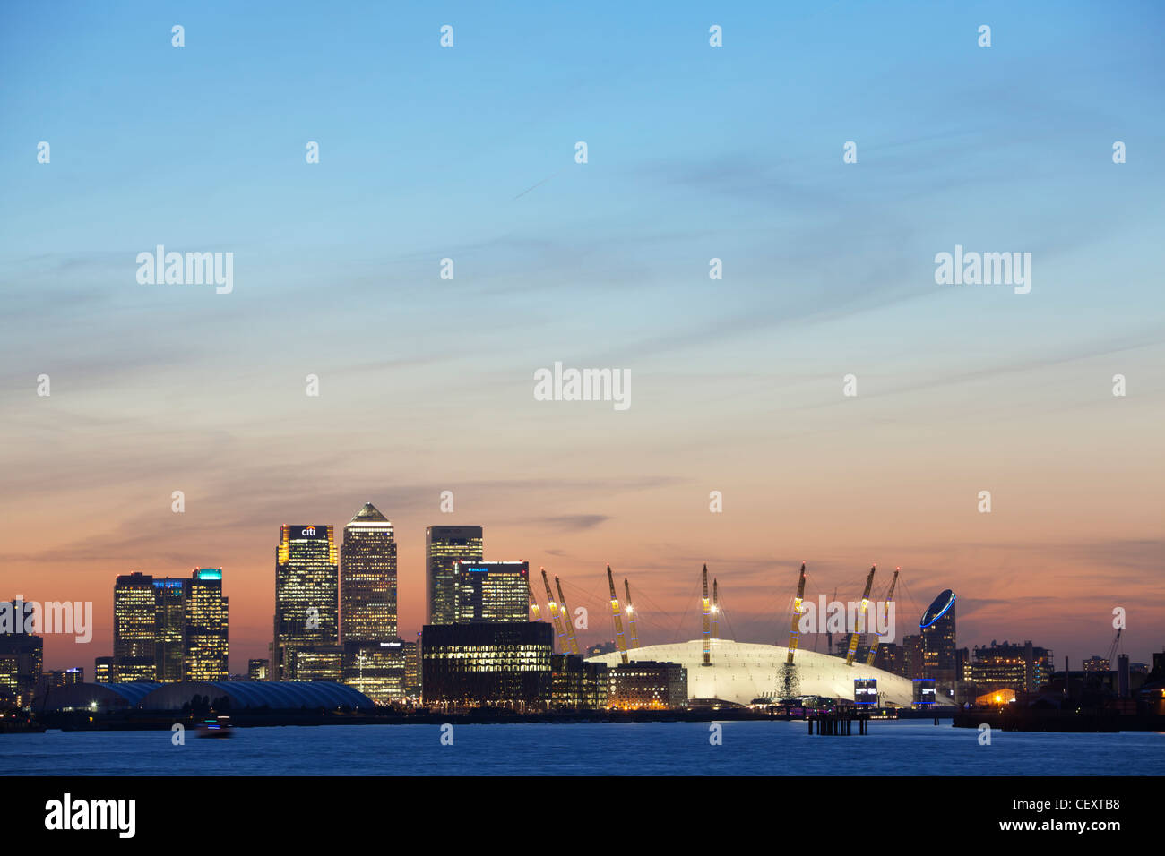 Ein Blick auf th Fluss Themse gegenüber der City of London und die O2 Arena und Canary Wharf bei Sonnenuntergang Stockfoto