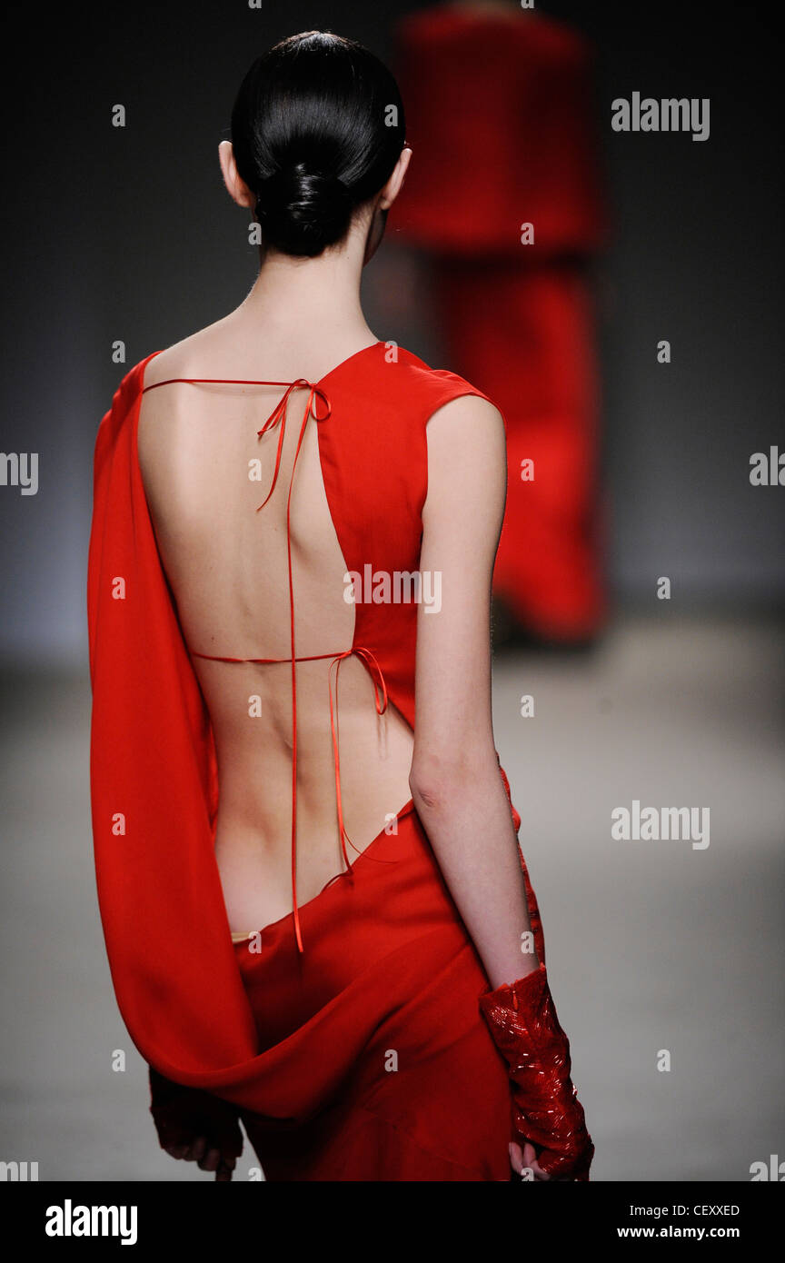 Thimister Paris Haute Couture bereit zu tragen Herbst Wintermodell trägt ein leuchtendes rotes Kleid öffnen zurück und rote fingerlose Handschuhe Stockfoto