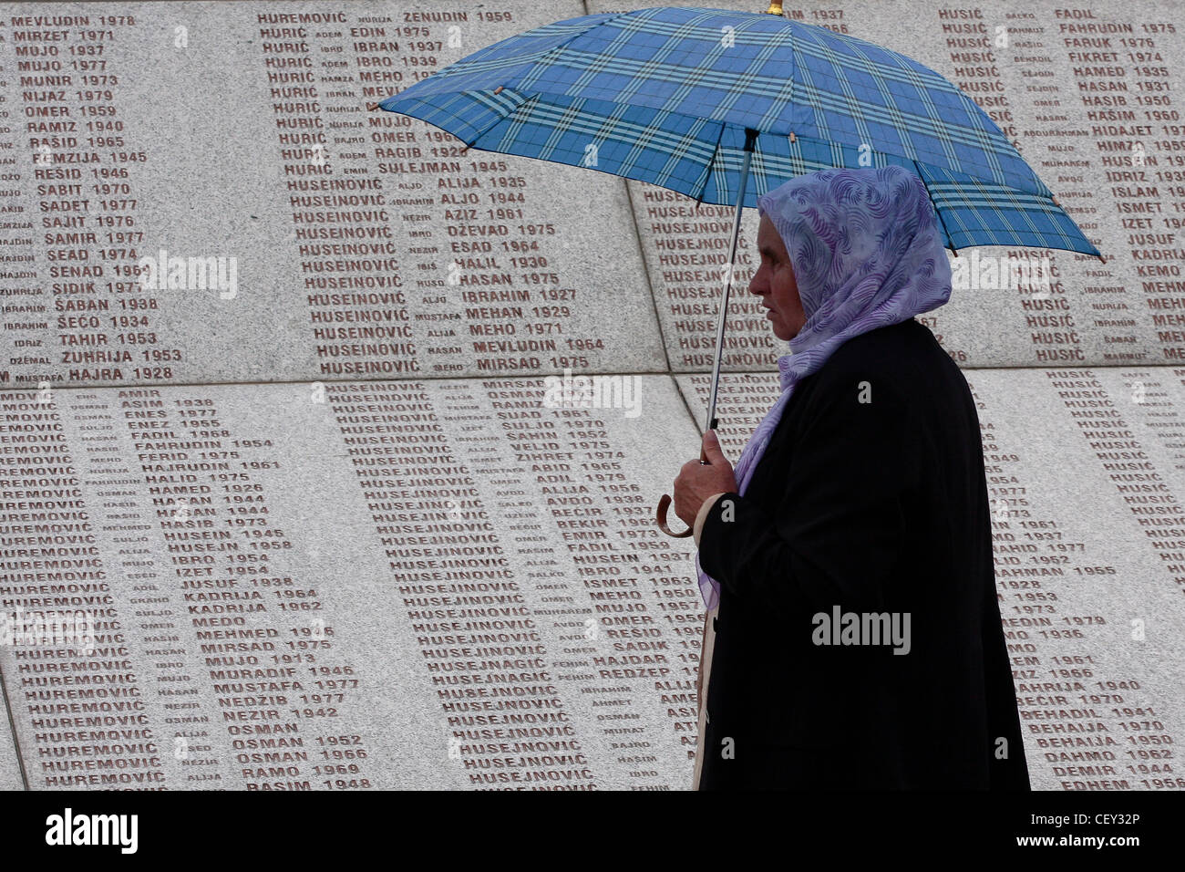 Eine bosnische Muslimin vorbei Denkmal mit den 8372 Namen der Opfer des Massakers von Srebrenica im Jahr 1995. Stockfoto