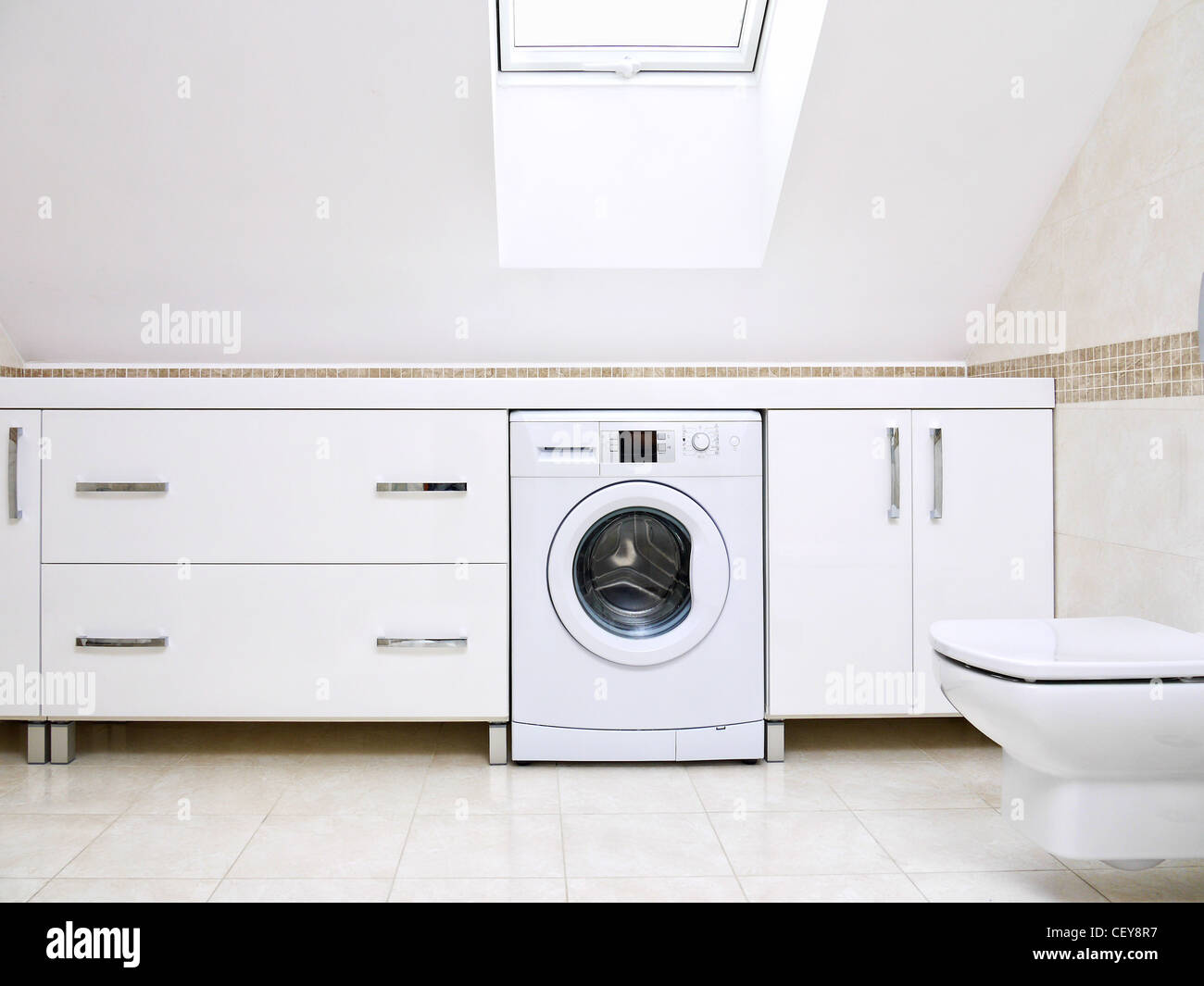 Modernes Badezimmer mit glänzenden weißen Schränke und Waschmaschine Stockfoto