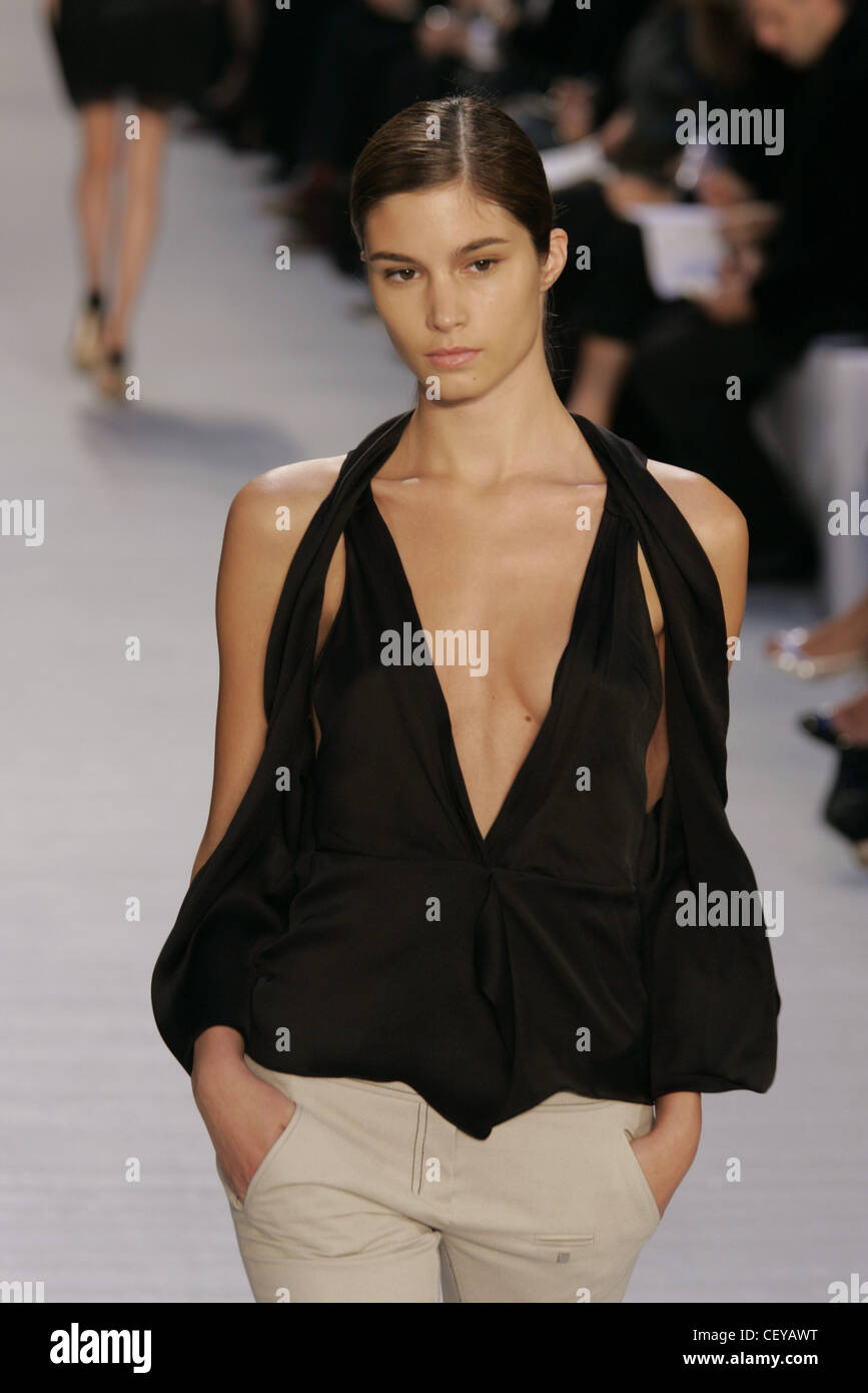 Paco Rabanne weiblichen Modell dunkelbraunes Haar zog sich zurück, trägt ein tiefes V schwarze Bluse Schulter geschnitten Ärmel ausgeschnitten, die im Blätterteig Stockfoto