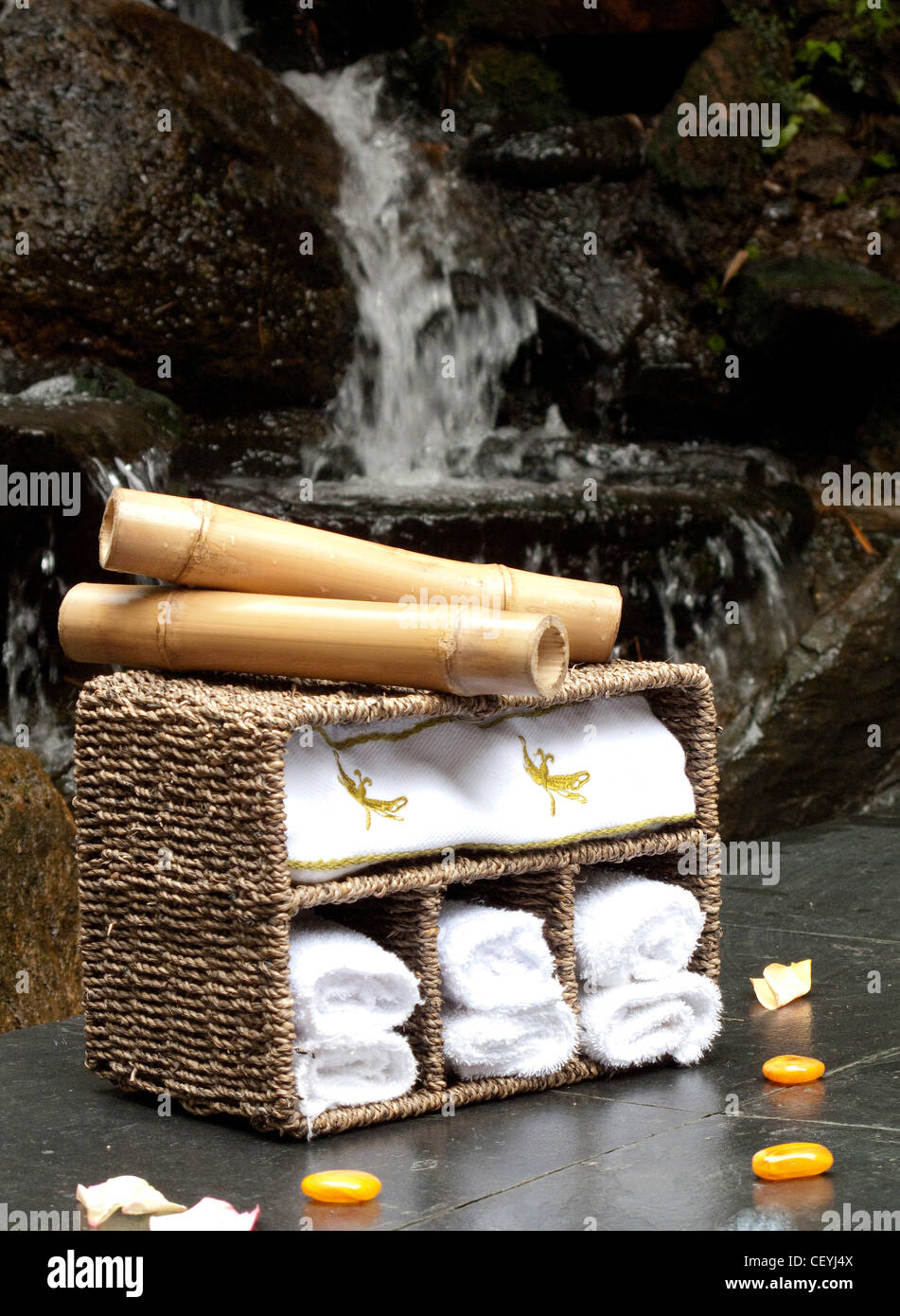 Still Life Bild Rattan Handtuch Lagereinheit mit Bambus klebt auf der Oberseite und Wasserfall im Hintergrund Stockfoto