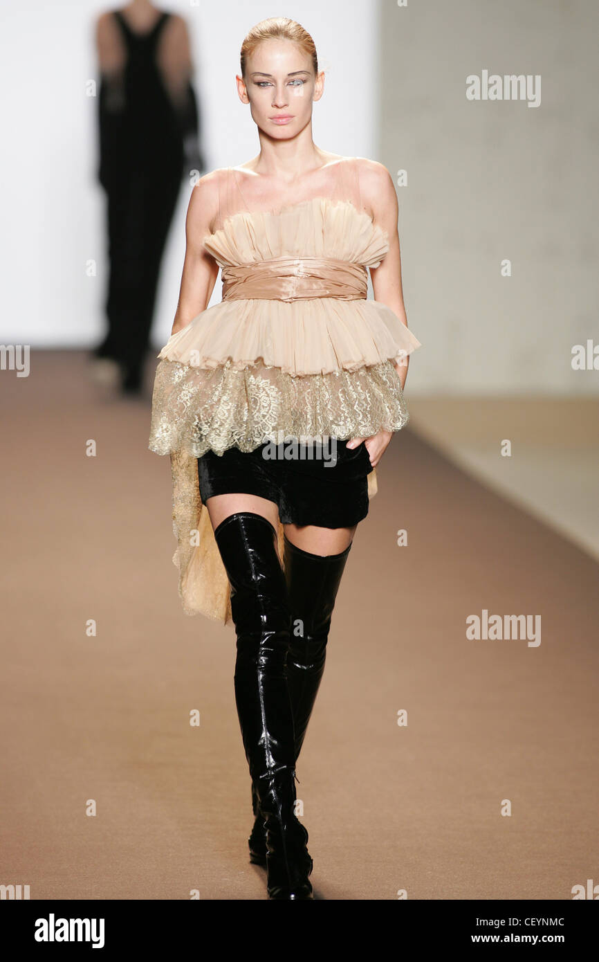 Anna Molinari Mailand bereit zu tragen Herbst Winter Scrunched geschichtet Bluse Schärpe über schwarzen Minirock und schwarze pvc Overknee Stiefel Stockfoto