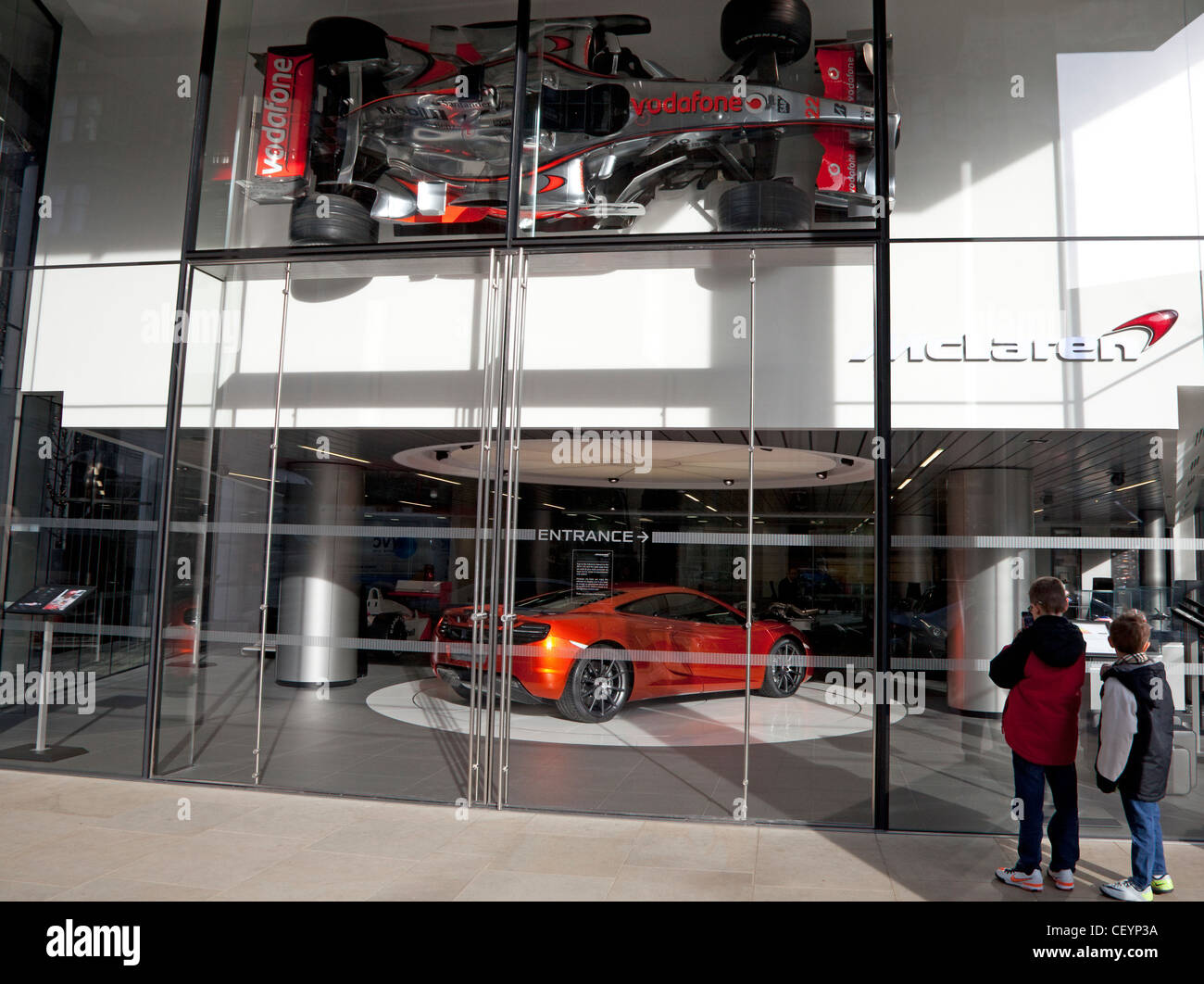 Jungen bewundern McLaren Supersportwagen in London showroom Stockfoto