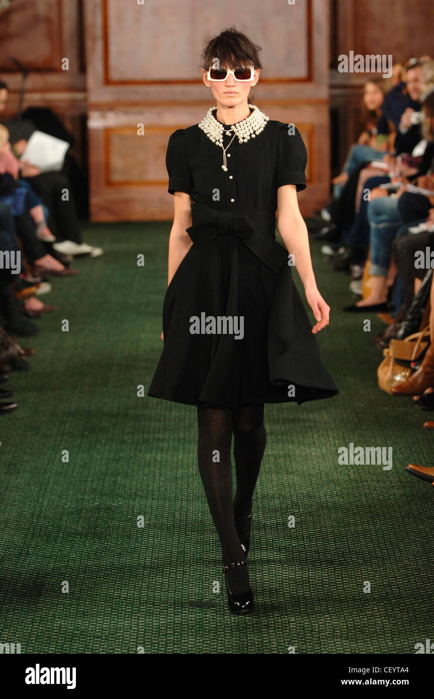 Luella New York bereit zu tragen-Herbst-Winter-Brünette weibliches Modell tragen Quadrat geformt weißen Rahmen Sonnenbrillen Mitte Oberschenkel Stockfoto