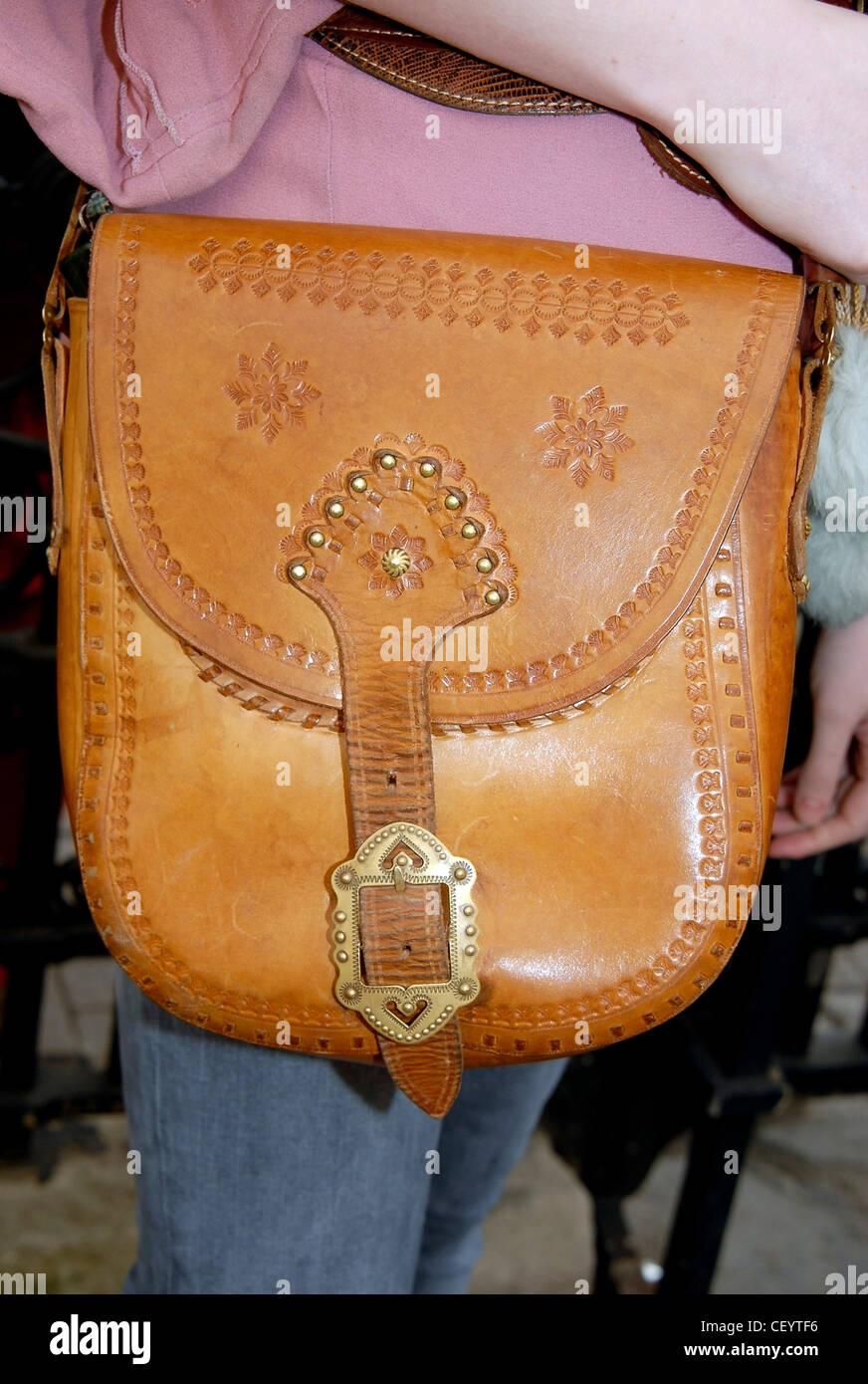LONDON A W zeigt MISCELLANY Nahaufnahme einer braunen Leder-Handtasche mit Mustern der Marke hinein getragen von einer Frau Stockfoto