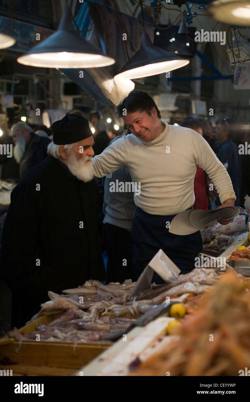 Griechisch-orthodoxe Priester kauft Meeresfrüchte aus einem Stall in Athen Zentralmarkt auf Athinas Street. Athen, Griechenland Stockfoto