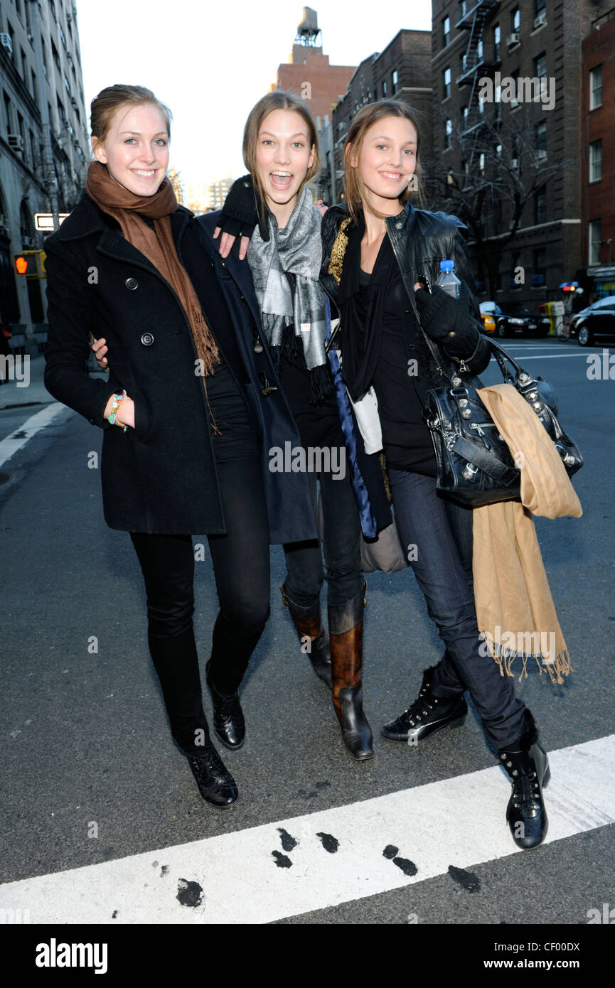 New York Street Style drei Weibchen tragen von linken, engen schwarzen Trouses, schwarzen wollenen double breasted Mantel einen braunen Schal Stockfoto