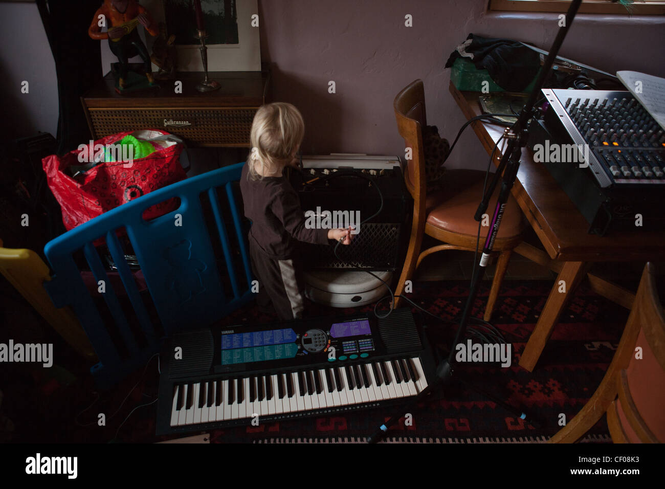 Einjähriges Kleinkind mit seiner Eltern Musik-Equipment zu Hause spielen, Elektronik, Kabel, Verstärker, Tastatur. Stockfoto