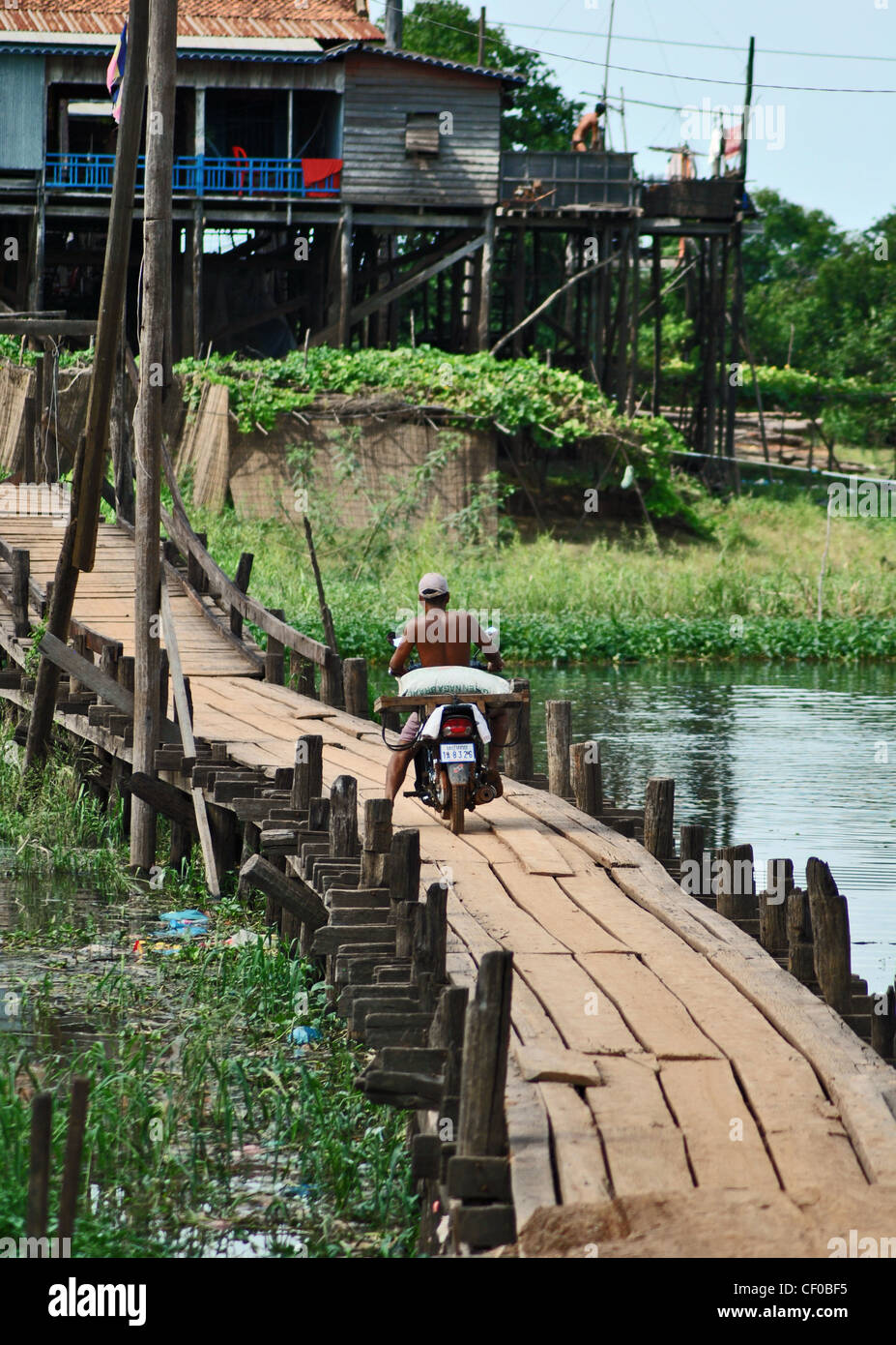 Ein Motorrad überquert eine Brücke in Kompong Khleang Dorf, Tonle Sap, Kambodscha Stockfoto