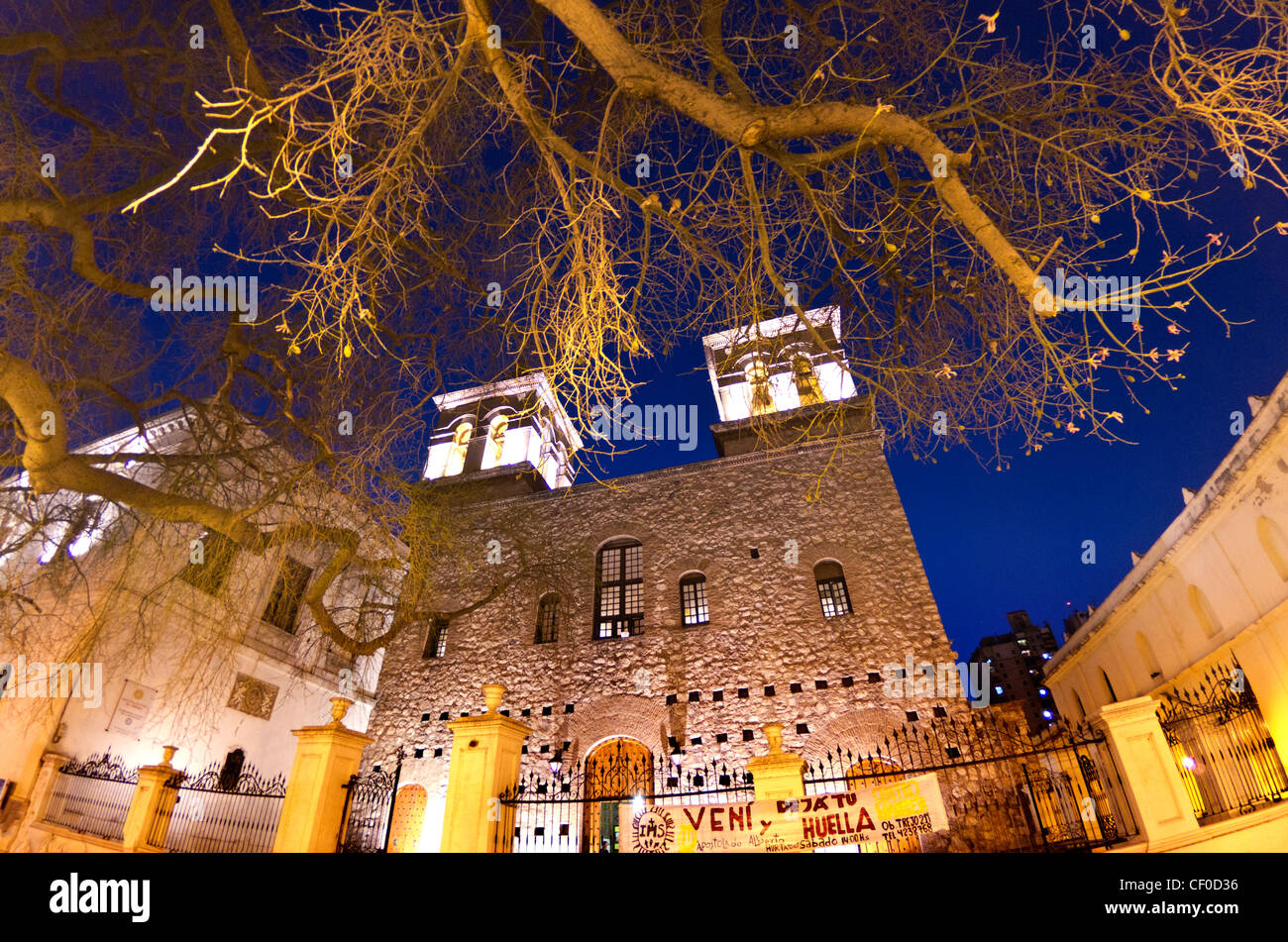 eine Kirche außen am Abend mit hellen Lichtern und einem Zaun in Cordoba, Argentinien Stockfoto