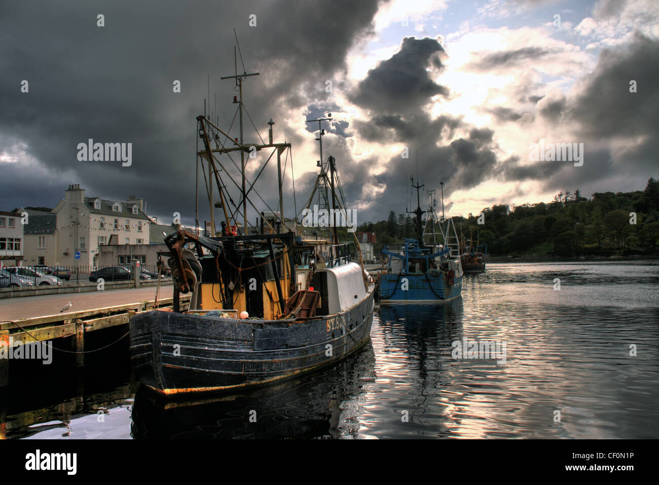 Traditionelle Fischerboote und ein dramatischer Himmel in Stornoway Hafen, Western Isles, Schottland, Vereinigtes Königreich Stockfoto