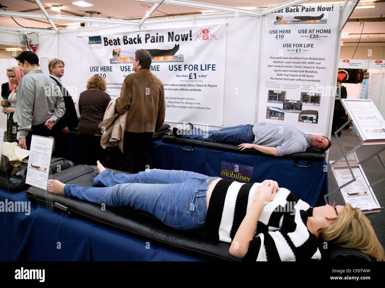 Menschen, die mit dem Mobilisierer Bett zur Behandlung von Rückenschmerzen bei Back in Action stehen, die Rückenschmerzen zeigen, London UK 2012 Stockfoto