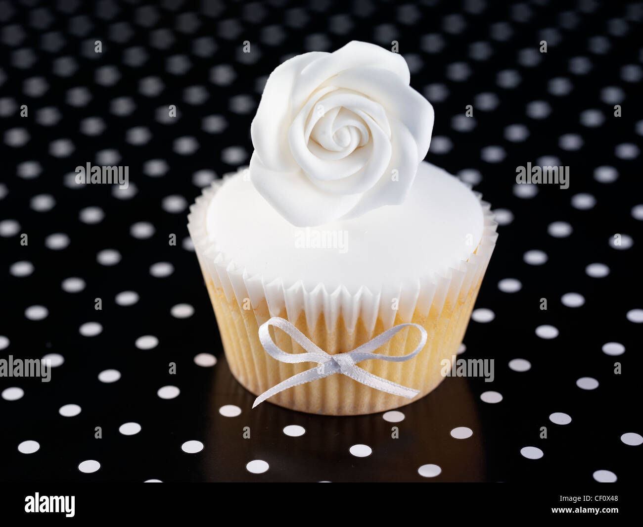 WEIßE ROSE CUPCAKE AUF SCHWARZ Stockfoto