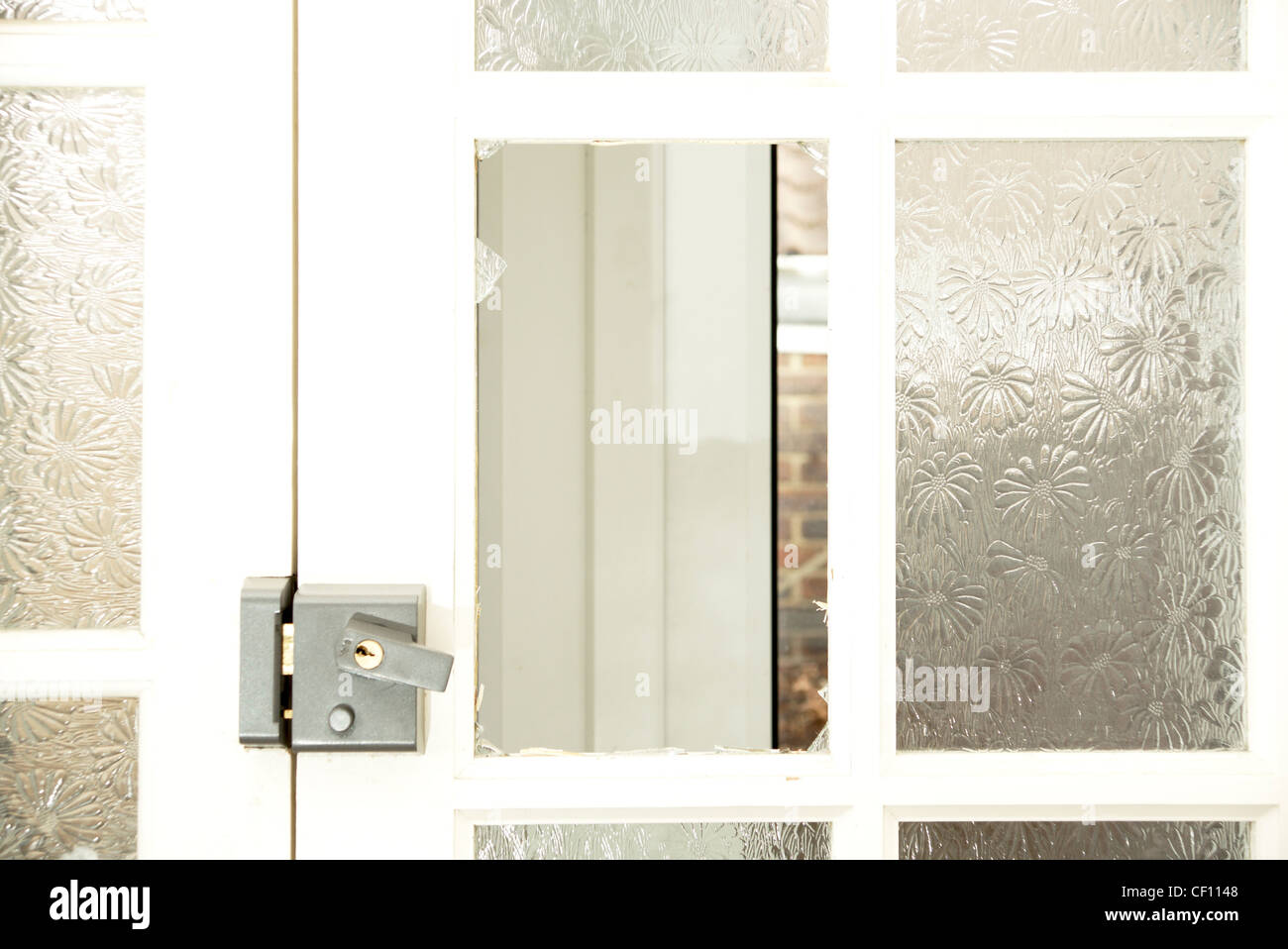 Fensterscheibe in einer Haustür mit zerschmetterten gebrochen & Glasscherben Stockfoto
