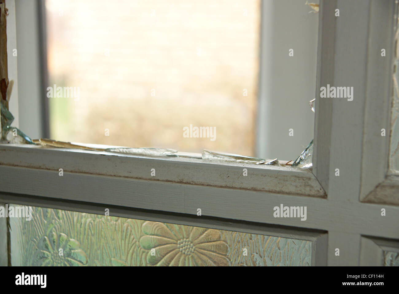 Fensterscheibe in einer Haustür mit zerschmetterten gebrochen & Glasscherben Stockfoto