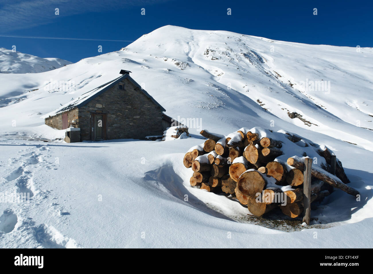 Brennholz gestapelt außerhalb einer Berghütte in verschneite Berglandschaft in der Nähe von Col de Pause, Ariege, Pyrenäen, Frankreich. Stockfoto
