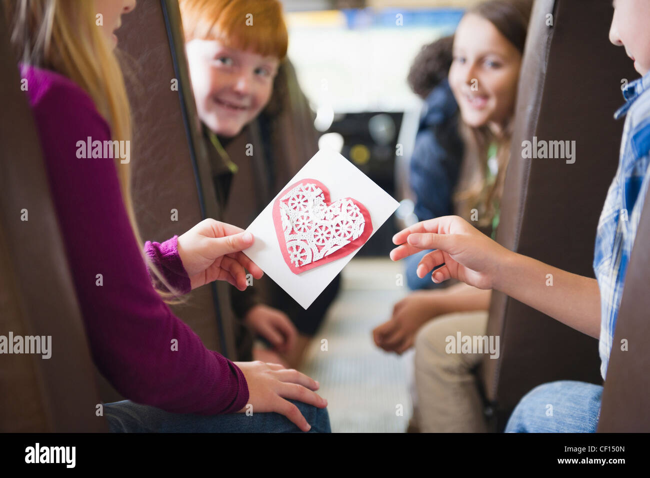 Mädchen geben Valentine Freund auf Schulbus Stockfoto