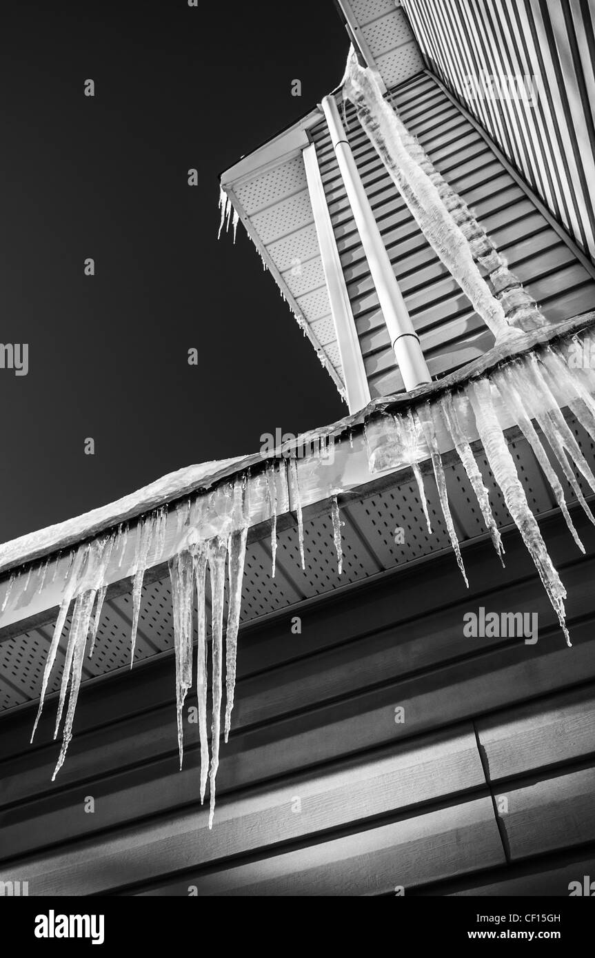 Gefrorenen Eiszapfen hängen von einem Wohngebäude im Winter. Stockfoto