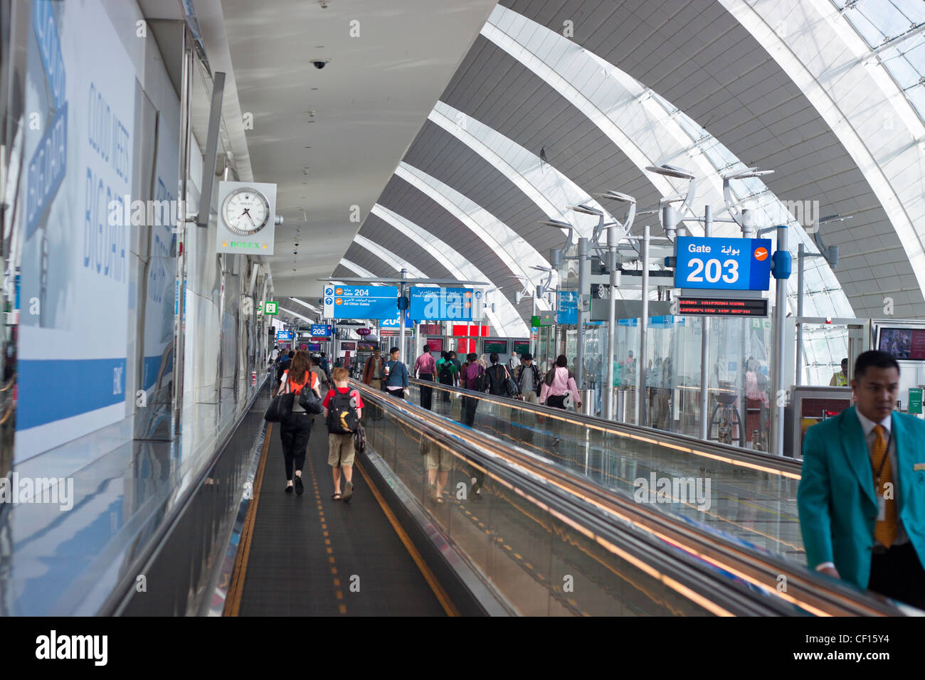 Menschen gehen durch den Flur der Flughafen Dubai International Airport, Dubai, Vereinigte Arabische Emirate. Stockfoto