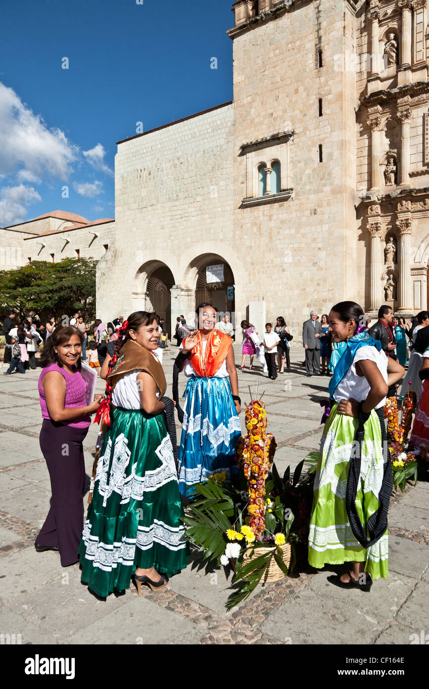 drei indigenen mexikanischen Inderinnen Tänzer in bunten traditionellen Kleid entspannend auf Kirche Plaza nach dem Tanzen in einer Prozession Stockfoto