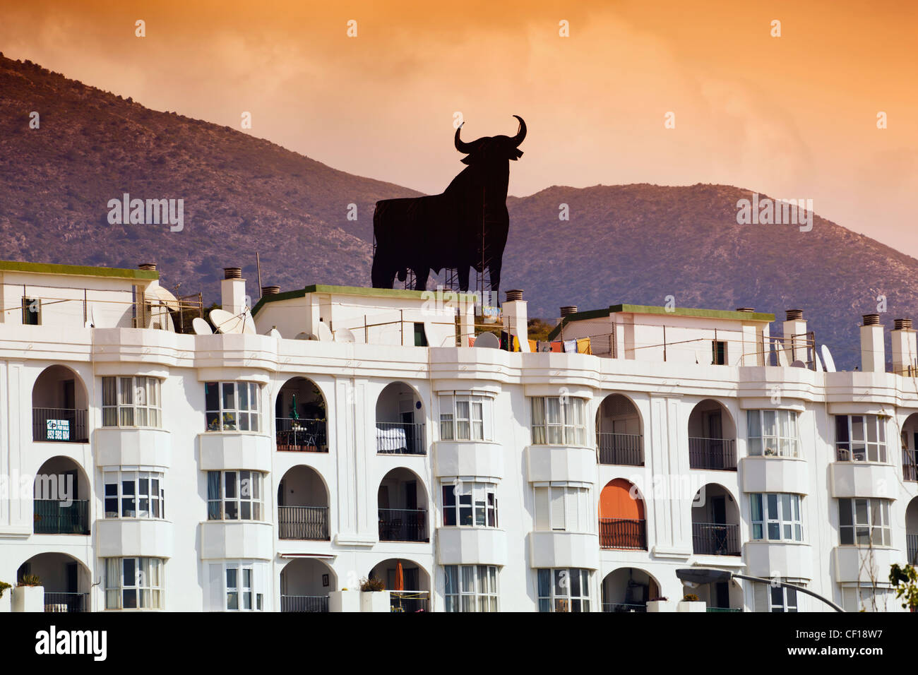 Der schwarze Osborne Stier sitzt auf einem Hügel hinter Los Boliches Silhouette; Fuengirola Provinz Malaga Costa Del Sol Spanien Stockfoto