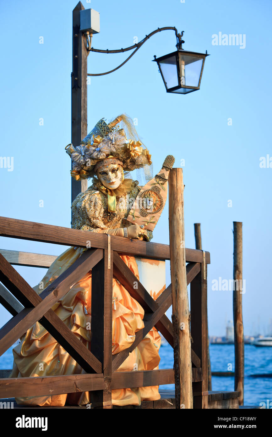 Maskierte Frau auf einem Pier während des Karnevals von Venedig, Venetien, Italien stehend Stockfoto