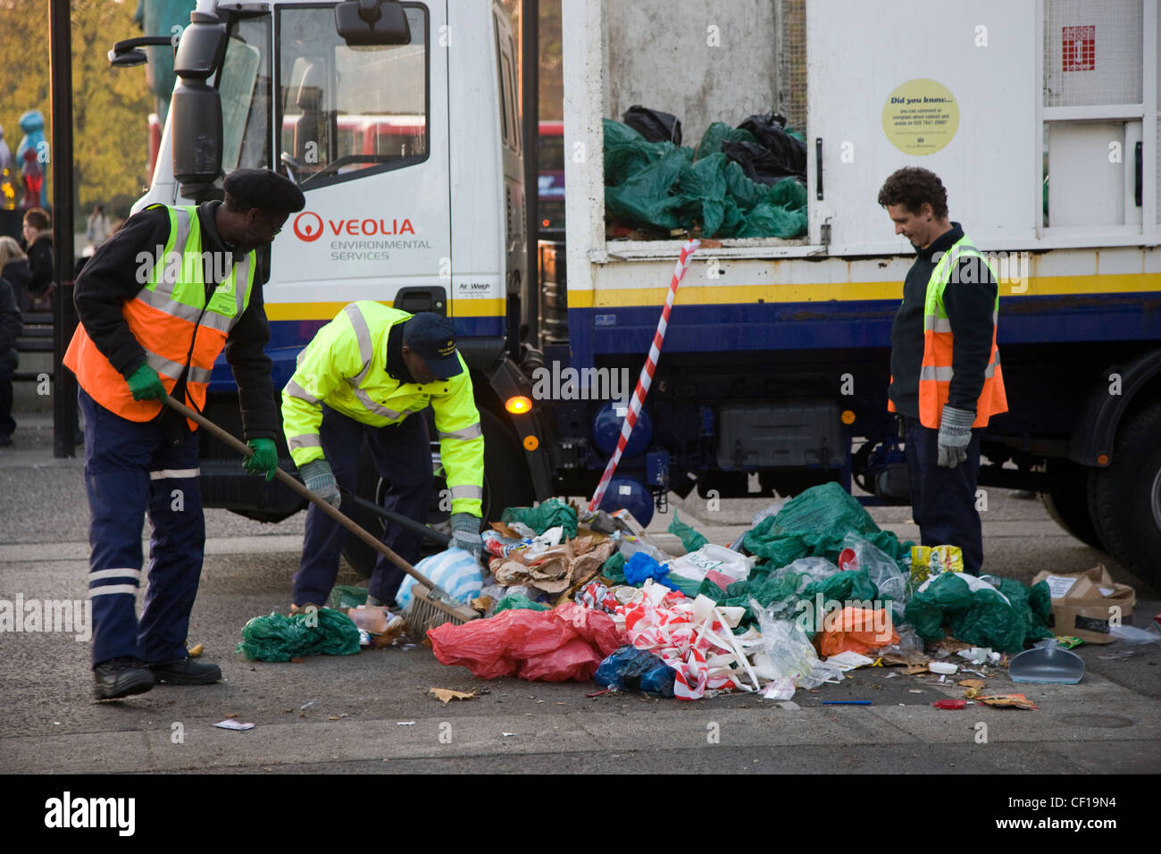 Männer in High-Visibility-Jacken clearing Müll in einem Müllwagen geparkt auf dem Bürgersteig gegenüber Marble Arch in London Stockfoto