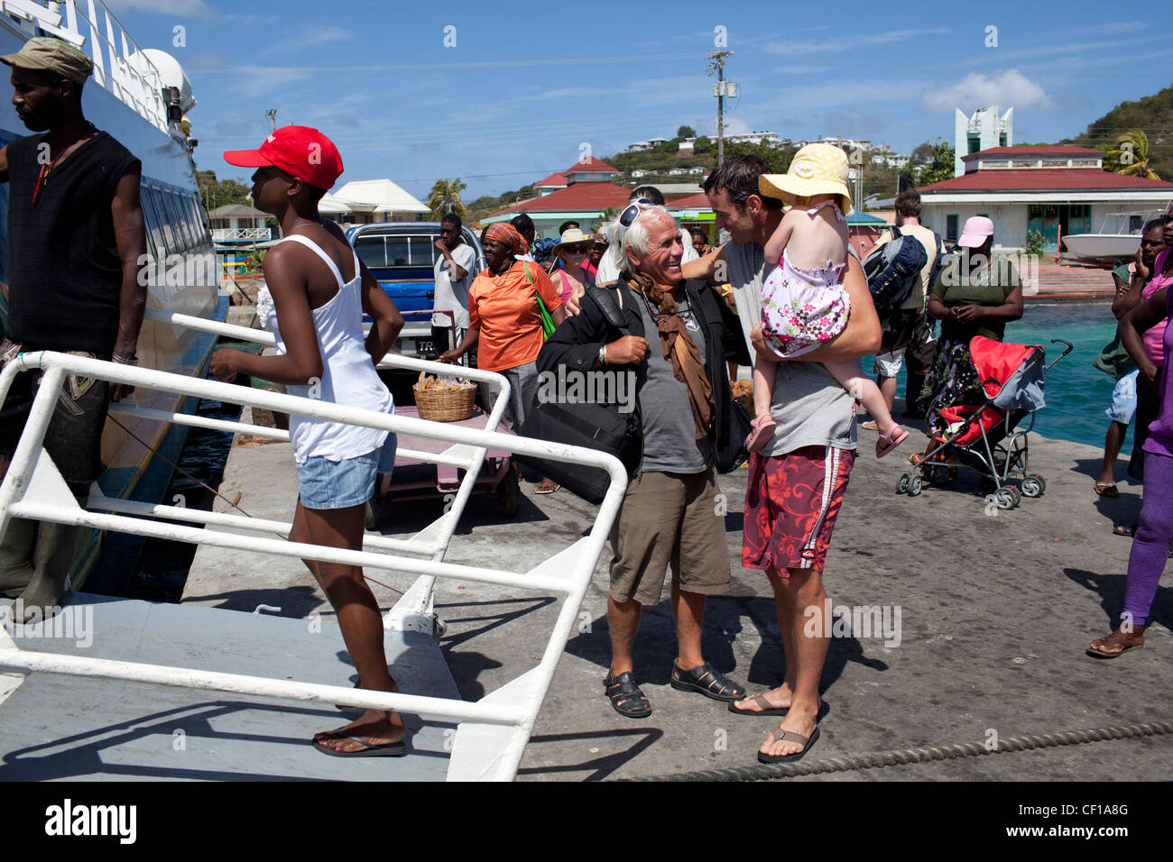 Touristen und Reisende von St. Vincent von Bord die Jaden Sonne-Fähre in den Hafen von Clifton, Union Island. Stockfoto