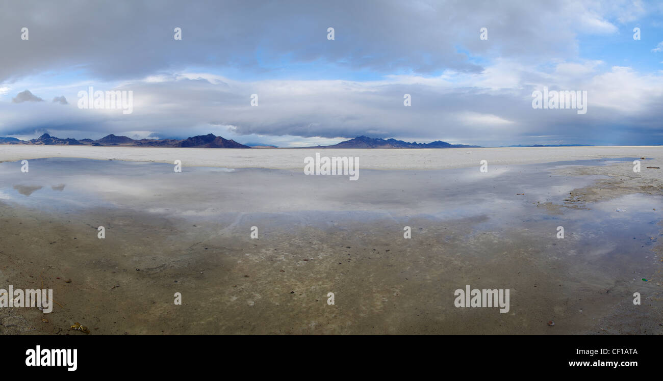 Panorama auf den Bonneville Salt Flats in Utah mit bewölktem Himmel und eine Pfütze im Vordergrund Stockfoto