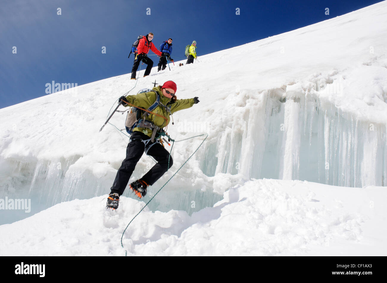 Eine Dame climber Springen eine große gletscherspalte an der Traverse des Monte Rosa in der Schweiz Stockfoto