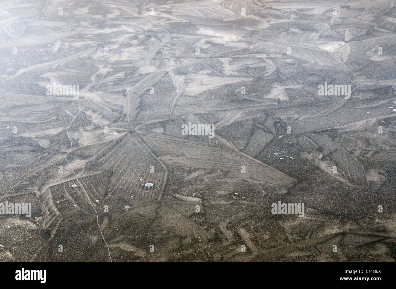 zugefrorenen Teich Oberfläche Risse Bläschen mit Eiskristallen Stockfoto