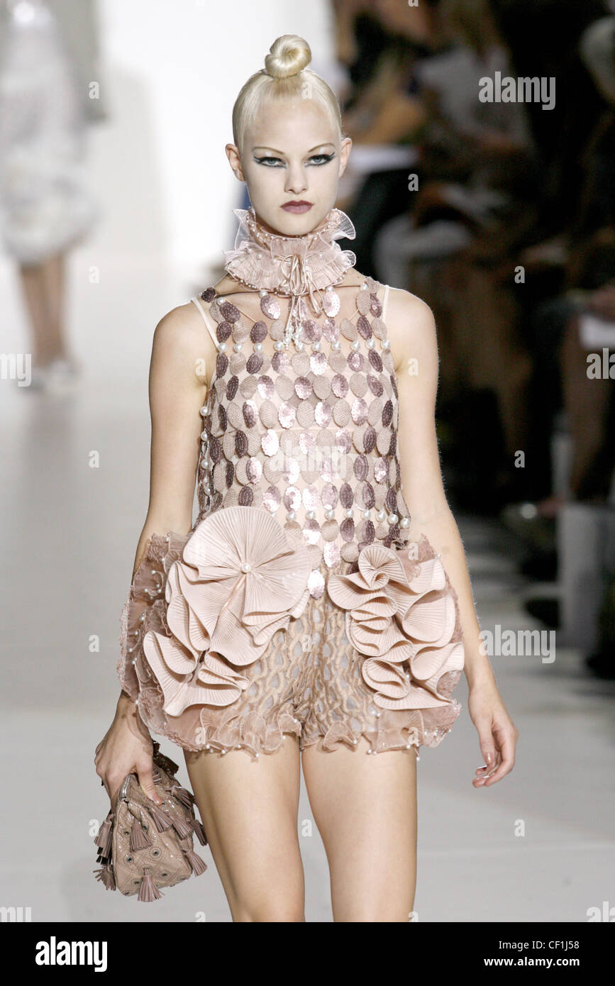 Ein staubiges rosa Sleevless verziert Top Pfirsich Crepe gekräuselte strukturierte Hotpants, eine rosa Spitzen Rüsche um den Hals und eine beige Stockfoto