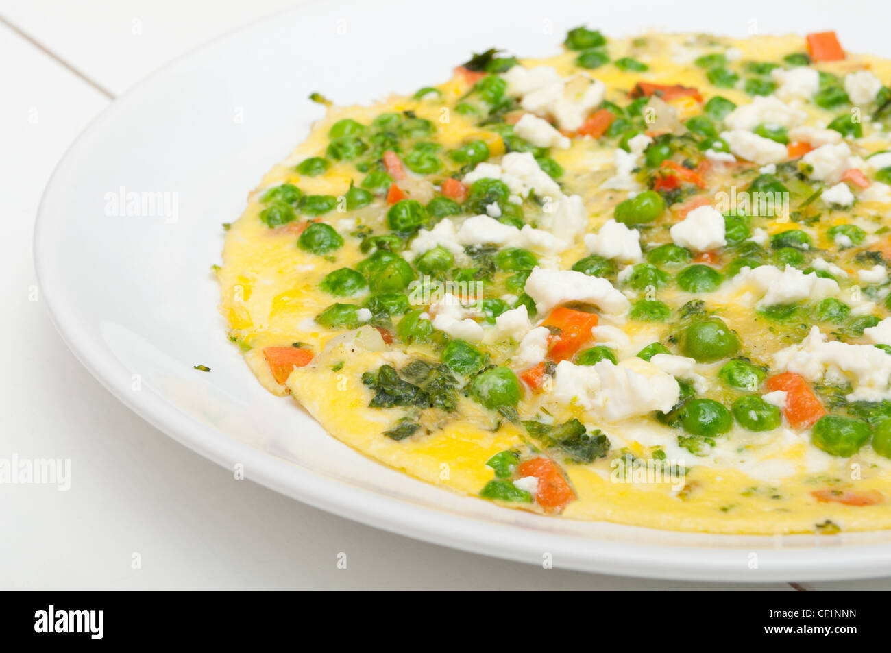 Ei-Omelette mit Feta-Käse, Tomaten und Erbsen Stockfoto