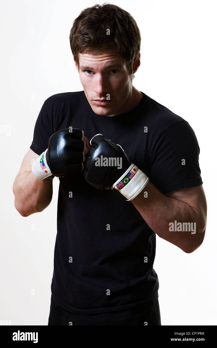 Ein Mann in einem Studio in einem Martial-Arts-Kampf tragen Boxhandschuhe Stockfoto