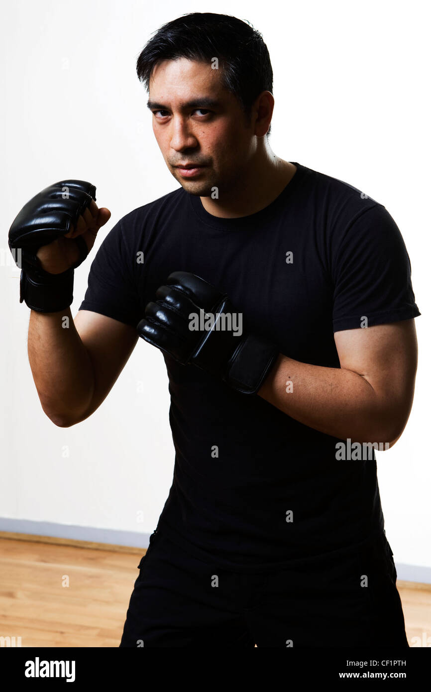 Ein Mann in einem Studio in einem Martial-Arts-Kampf tragen Boxhandschuhe Stockfoto