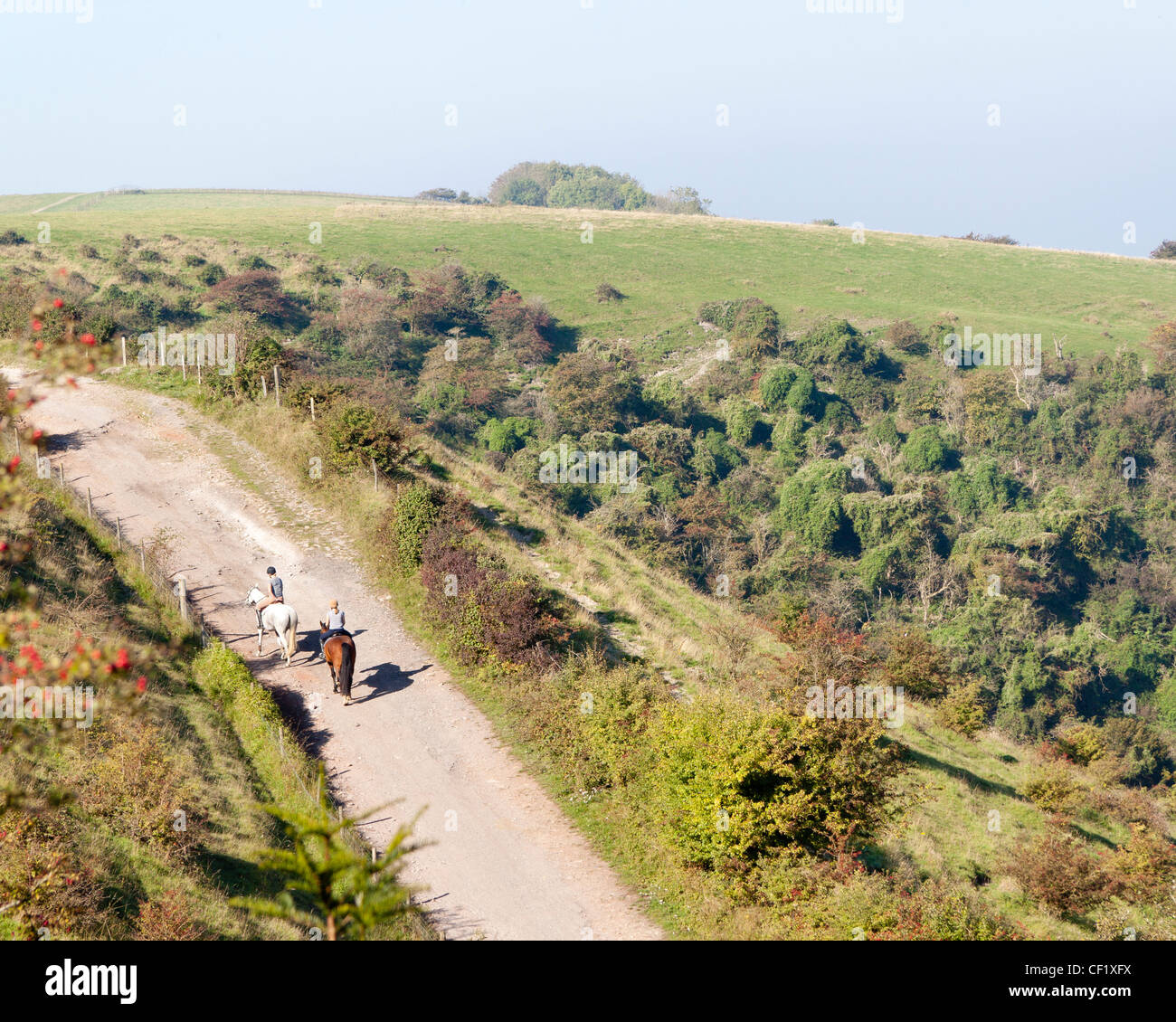 Zwei Frauen reiten auf Pferden entlang einer Gasse in den South Downs, East Sussex in der Nähe von Lewes Stockfoto