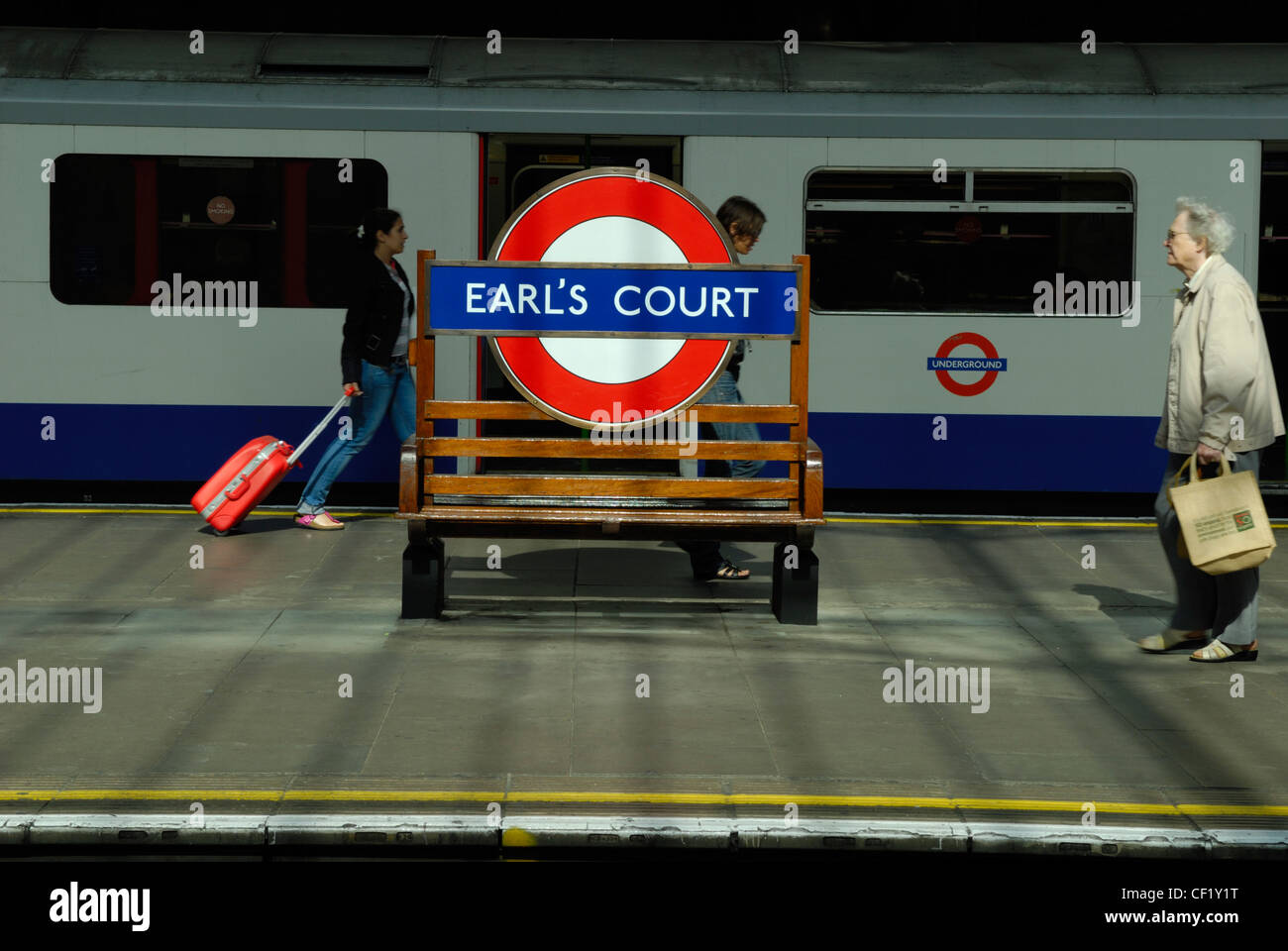 Passagiere, die zu Fuß entlang einer Plattform am Earls Court u-Bahnstation. Stockfoto