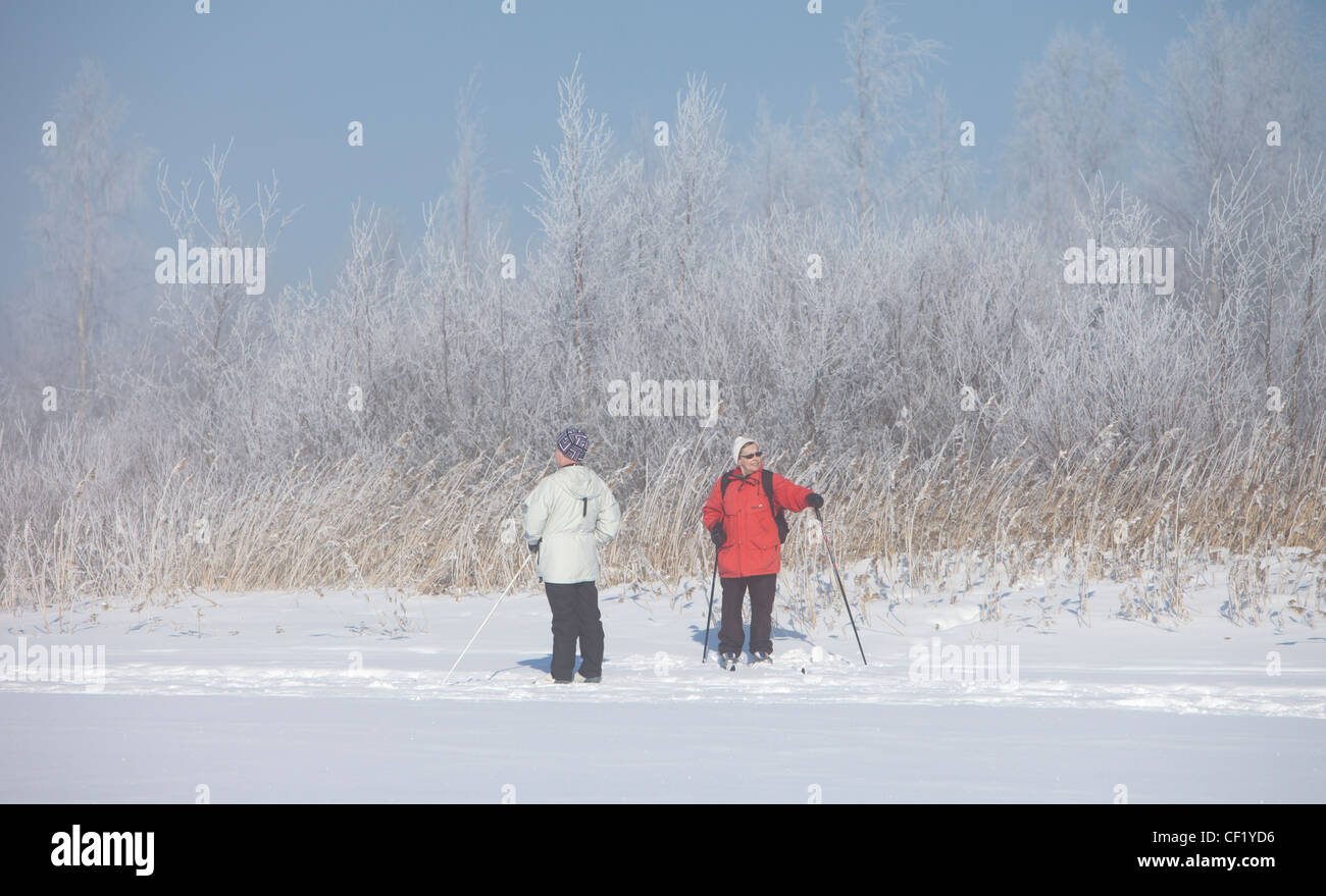 Zwei ältere Frauen ausruhen und sprechen auf Langlauf-Ski Reise, Finnland Stockfoto