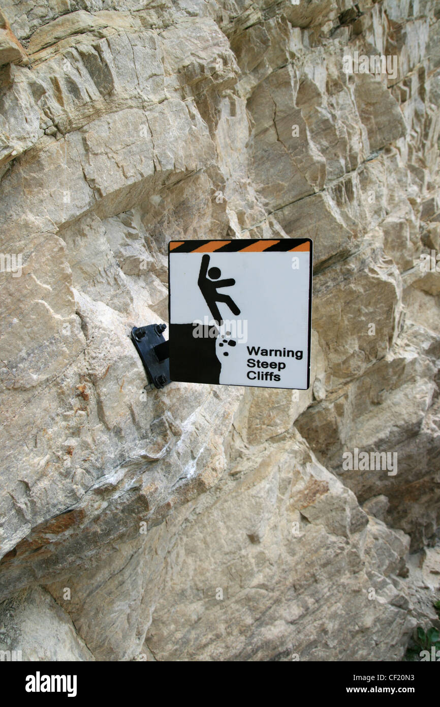 steile Klippen, die Warnzeichen zu einer steilen Stein Felswand verschraubt Stockfoto