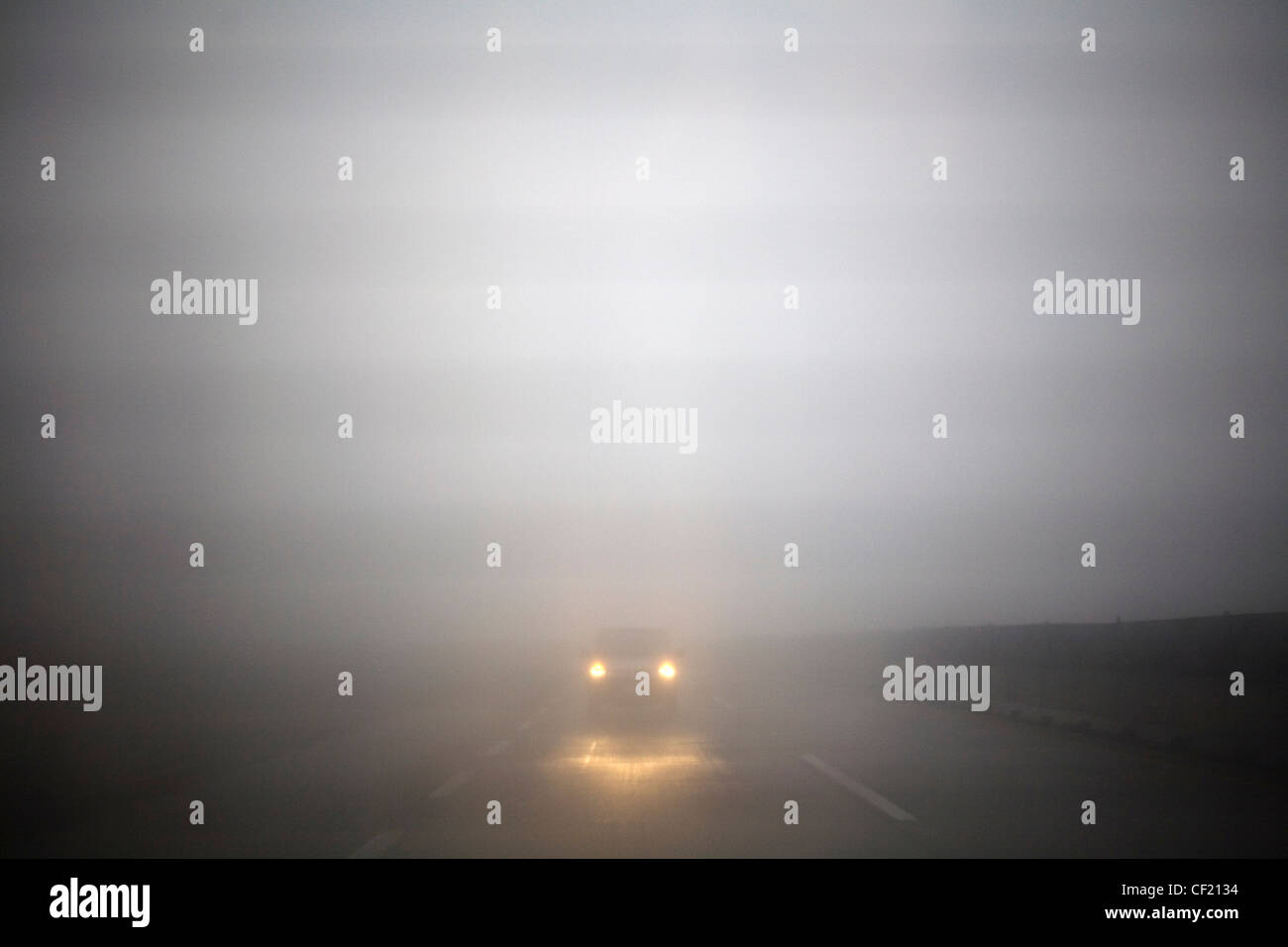 Ein Auto auf einer nebligen Straße. Stockfoto