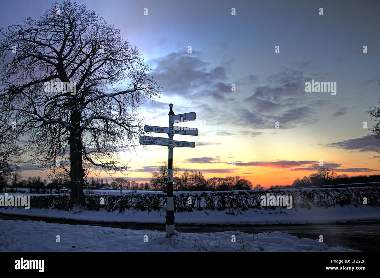 Budworth / Antrobus Dörfer Winter Sonnenuntergang und Fingerpost, Northwich, Cheshire, England, Großbritannien Stockfoto