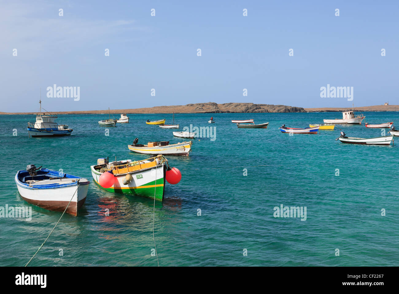 Blick über den Hafen auf die Insel Ilheu de Sal Rei mit Fischerbooten in türkisfarbenem Meer. Sal Rei, Boa Vista, Kapverdische Inseln Stockfoto