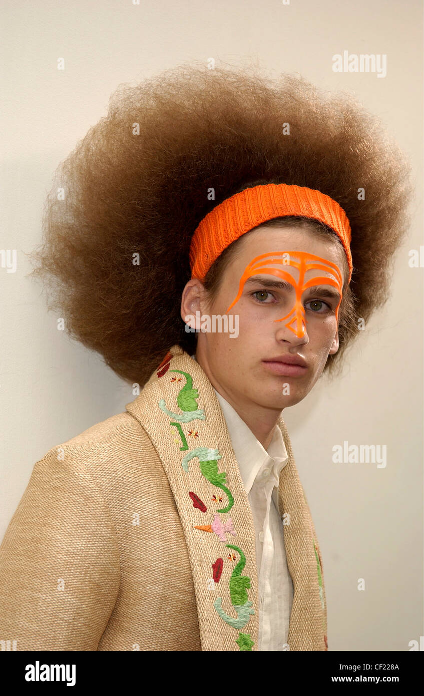 Walter van Beirendonck Paris Menswear S S Männermodel orange Stirnband in seiner Afro-Haar und orange Designs auf seinem Gesicht, tragen Stockfoto