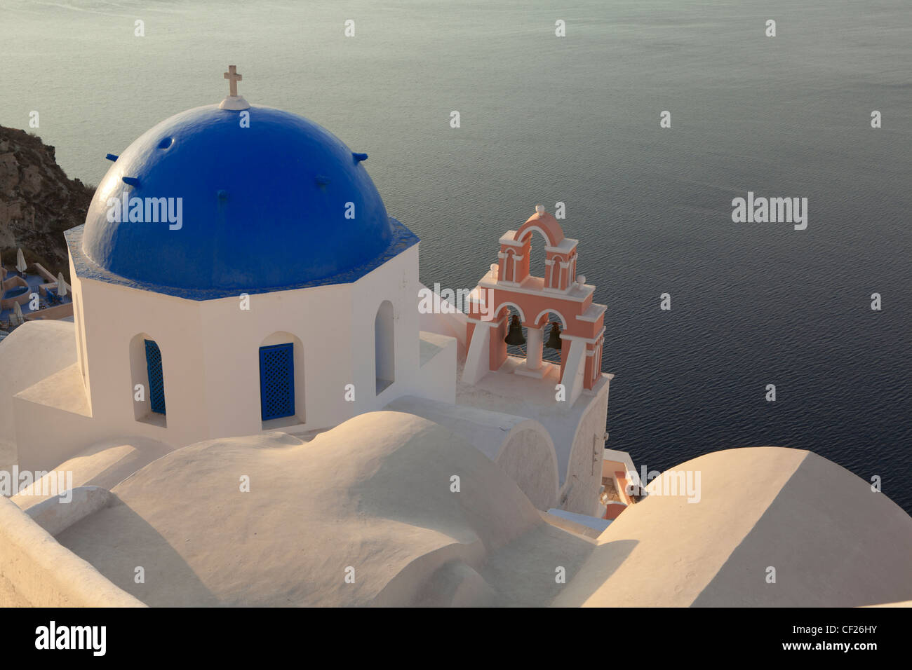 Einen Blick auf eine traditionelle blaue Kuppelkirche und ein rosa Glockenturm mit dem Meer hinaus Stockfoto